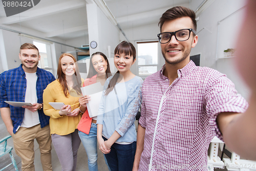 Image of creative business team taking selfie at office
