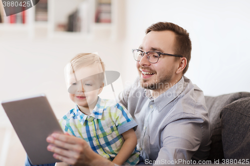 Image of father and son with tablet pc playing at home