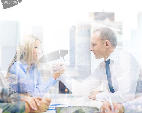 Image of businesswoman and businessman arm wrestling