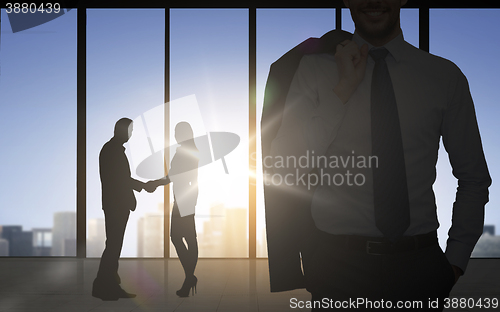 Image of business partners silhouettes shaking hands