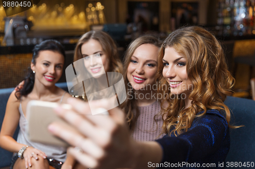 Image of women with smartphone taking selfie at night club