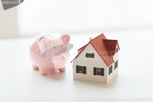 Image of close up of house model and piggy bank