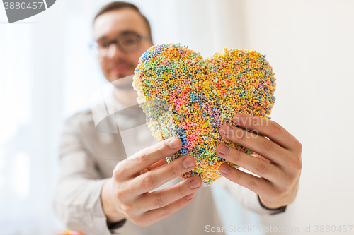 Image of close up of happy man with heart at home