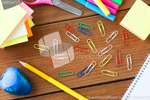 Image of close up of clips, pens and stickers on wood