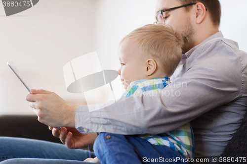 Image of father and son with tablet pc playing at home