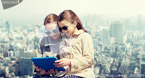 Image of happy girls with tablet pc computer over city