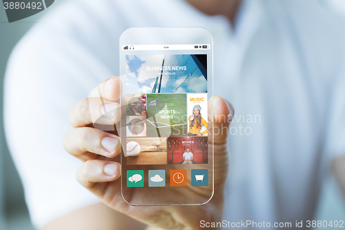 Image of close up of male hand with news on smartphone