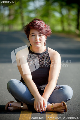 Image of Young Woman Sitting in the Road