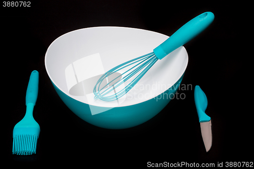 Image of Green silicone pastry brush and soup plate isolated on black