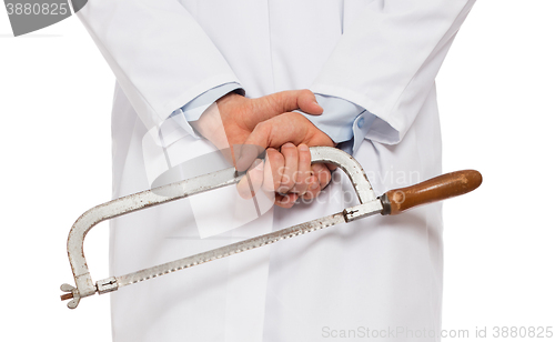 Image of Crazy doctor is holding a big saw in his hands