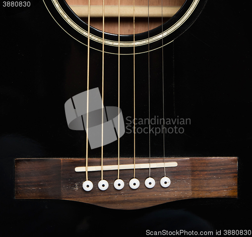 Image of Detail of an acoustic black guitar