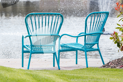 Image of Two blue chairs at the waterfront