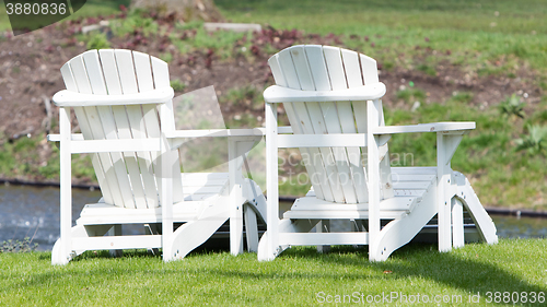 Image of Two white chairs at the waterfront