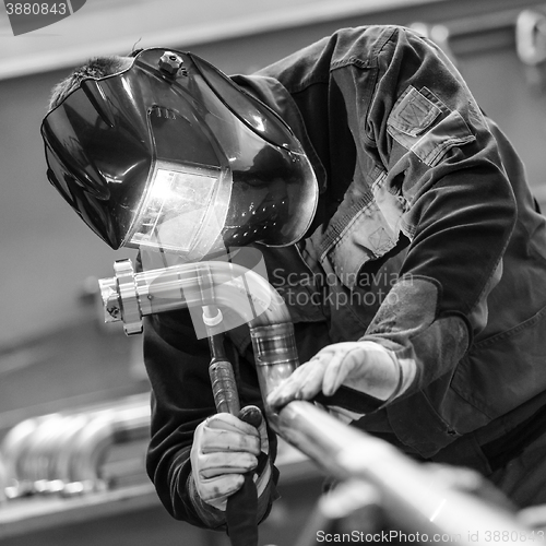 Image of Industrial worker welding in metal factory.