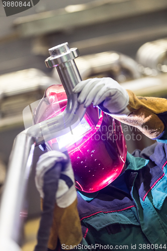 Image of Industrial worker welding in metal factory.