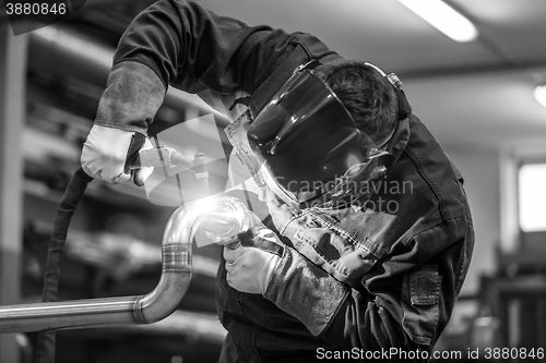 Image of Industrial worker welding in metal factory.