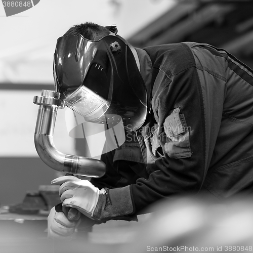 Image of Industrial worker welding in metal factory.