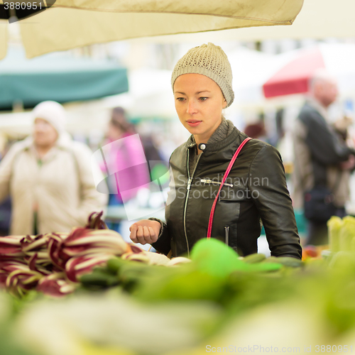 Image of Woman buying vegetable at local food market. 