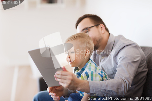 Image of father and son with tablet pc playing at home