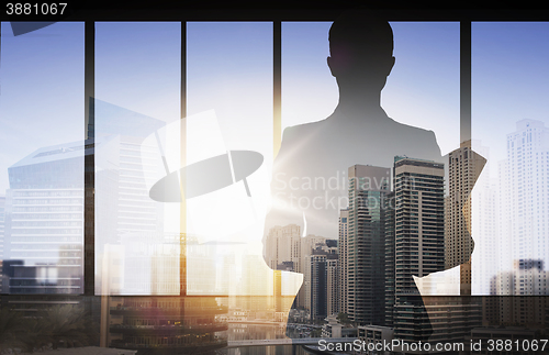 Image of silhouette of businesswoman with folder over city
