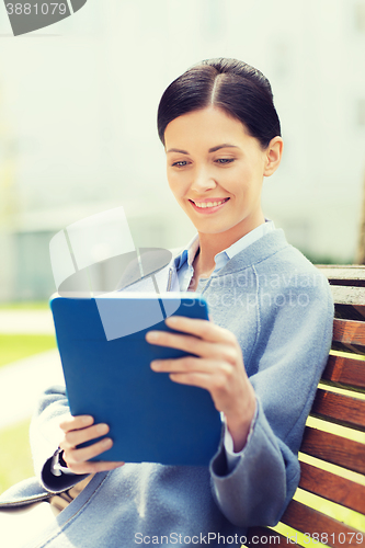 Image of smiling business woman with tablet pc in city