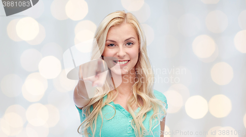 Image of happy young woman pointing finger to you