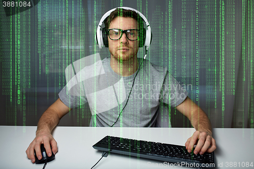 Image of man in headset playing computer video game at home