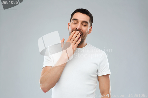 Image of yawning man over gray background
