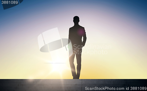 Image of silhouette of businessman over sun light