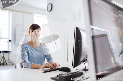 Image of happy asian woman with computer at office