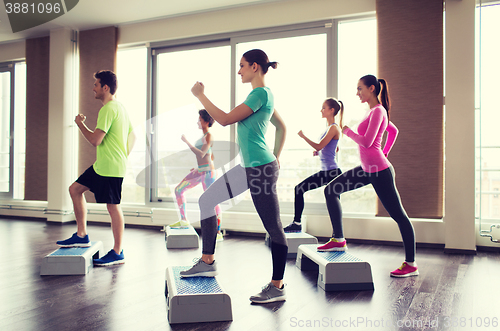 Image of group of people working out with steppers in gym