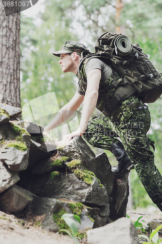 Image of young soldier with backpack in forest