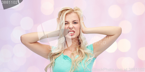 Image of young woman holding to her head and screaming