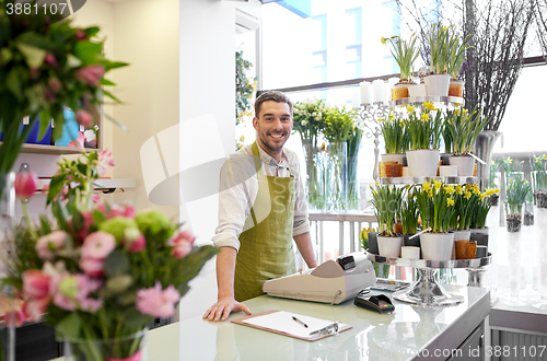 Image of florist man with clipboard at flower shop counter