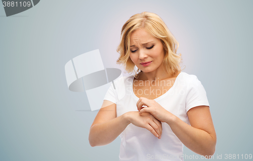 Image of unhappy woman suffering from hand inch