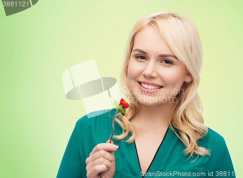 Image of smiling young woman eating vegetable salad