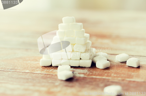 Image of close up of white sugar pyramid on wooden table