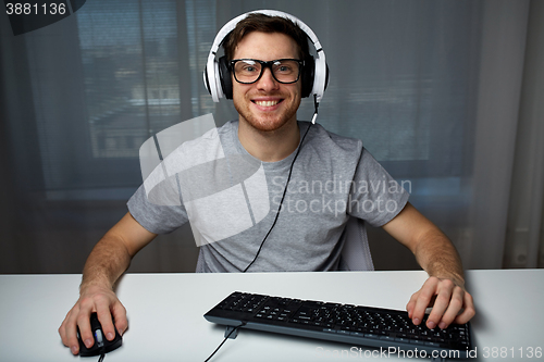 Image of man in headset playing computer video game at home