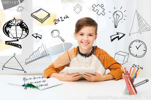 Image of smiling boy with tablet pc and notebook at home