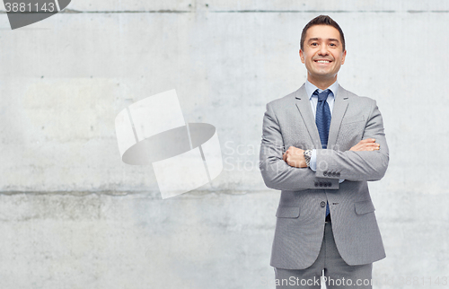 Image of happy businessman in suit over concrete wall