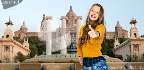 Image of happy young woman or teen girl showing thumbs up