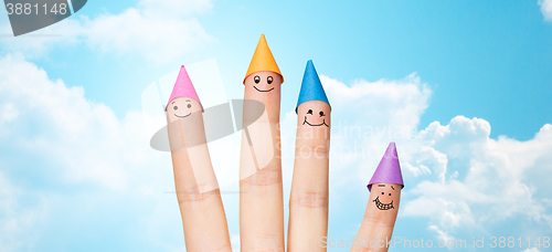 Image of close up of hand with four fingers in party hats