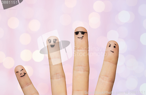 Image of close up of four fingers with smiley faces