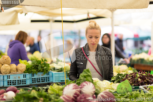 Image of Woman buying vegetable at local food market. 