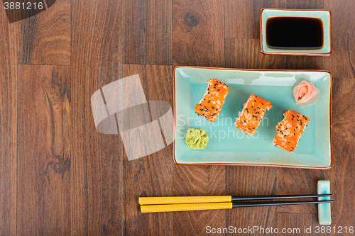 Image of Sushi rolls on the wooden table. Overhead view