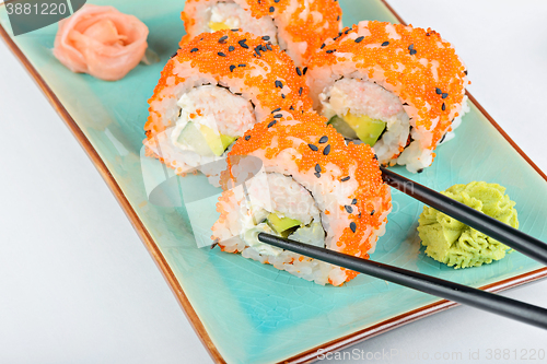 Image of Sushi roll with black chopsticks 