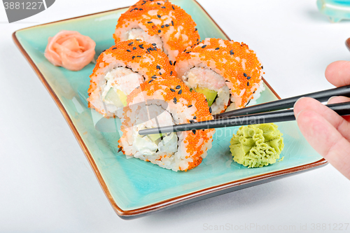 Image of Sushi roll with black chopsticks 