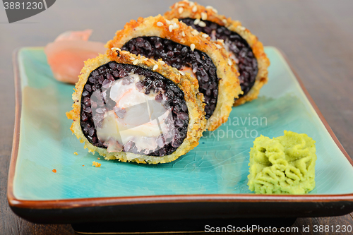 Image of Baked sushi rolls served on blue plate