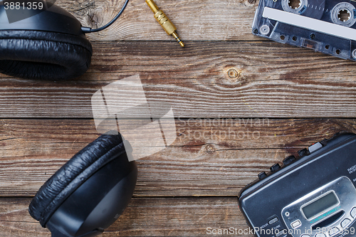 Image of Cassette tapes, cassette player and headphones over wooden table. top view.