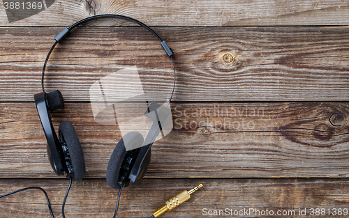 Image of Headphones over wooden table.